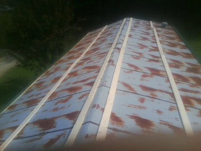 Rusted metal roof panels with new wood purlins before replacement — Storm Damage Roof Repair in Warwick by Roofing Brothers